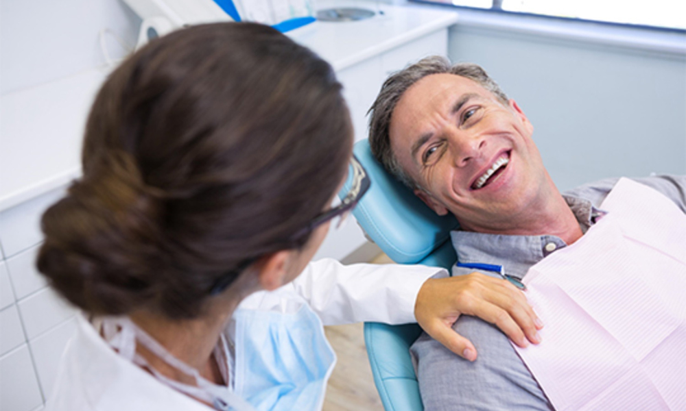 dentist discussing treatment and insurance with patient in dental chair Hendersonville TN