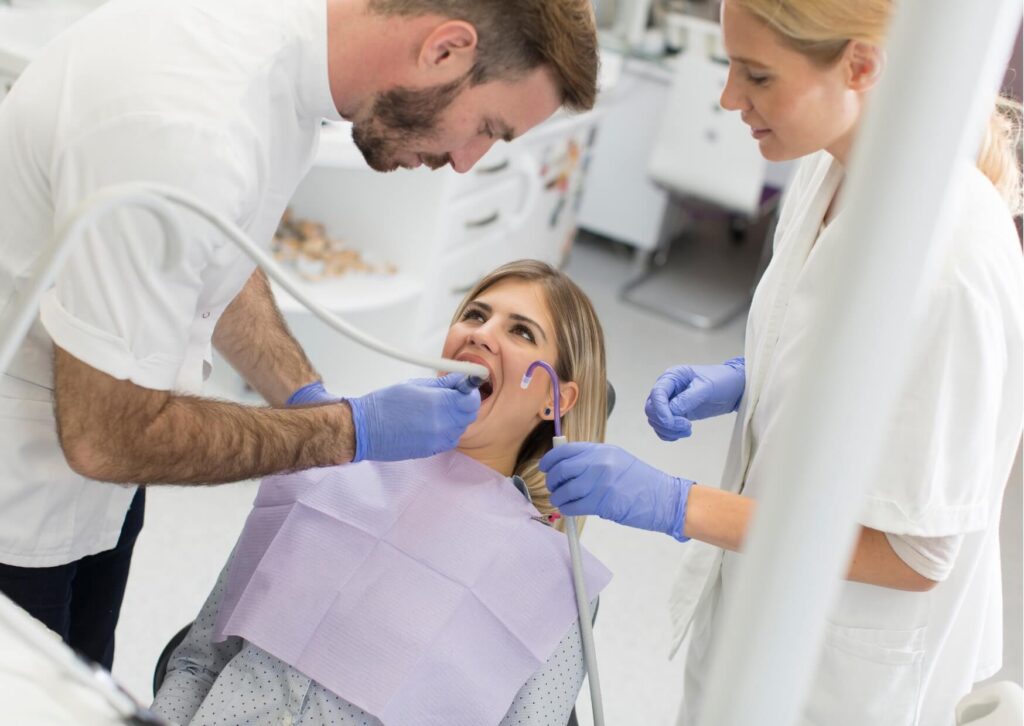 Dentist examining a patient's mouth during a checkup to evaluate how long it may take for a wisdom tooth to erupt.