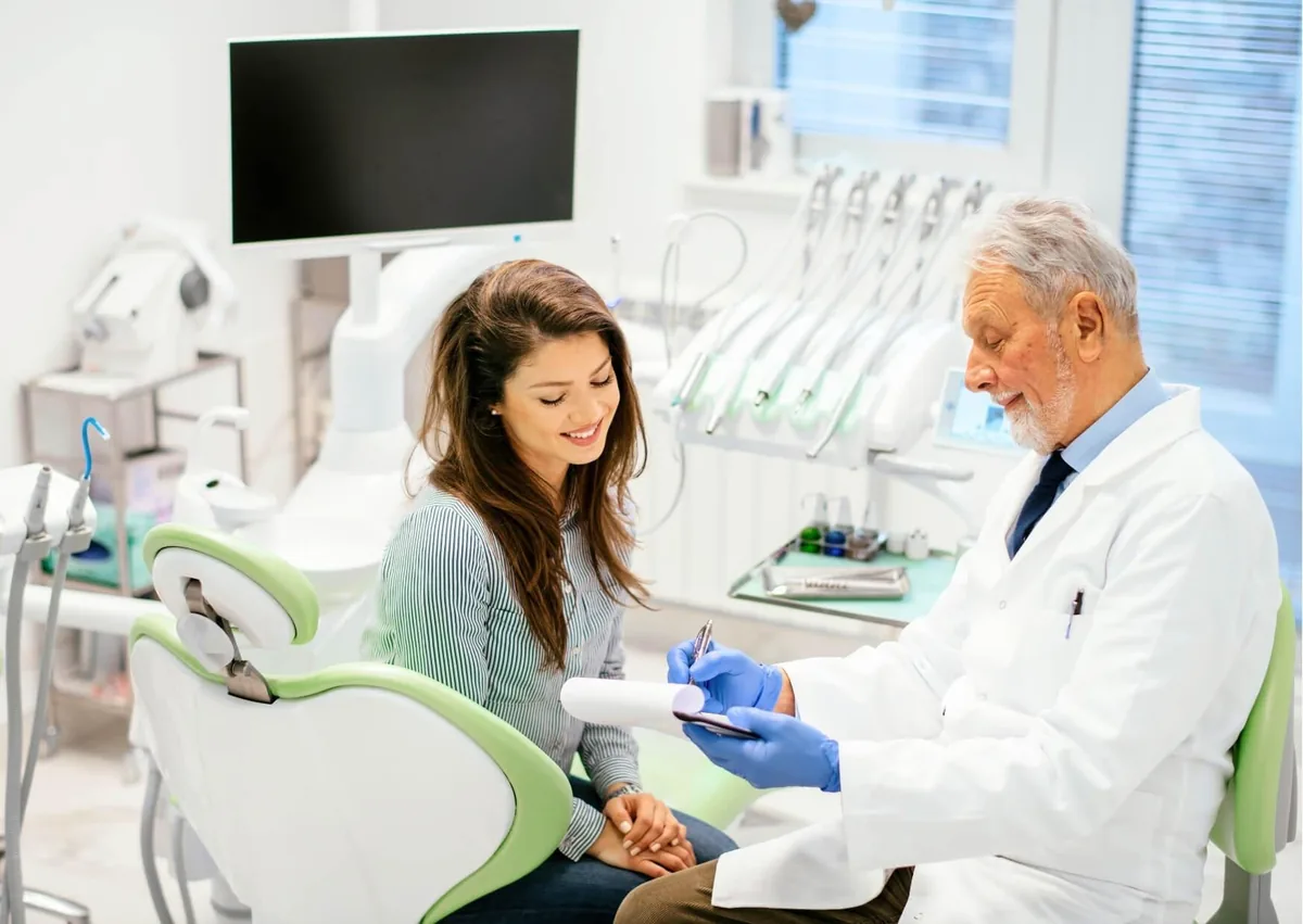 Dentist discussing recovery and soft foods to eat after dental implant surgery with a patient.