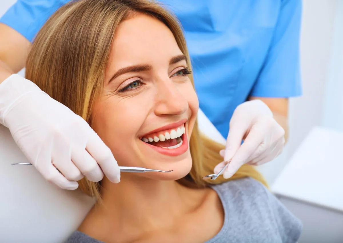 Smiling patient receiving a dental examination as part of cosmetic dentistry treatment.