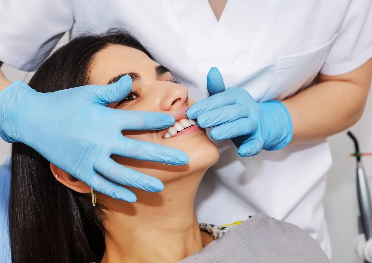 Dental professional examining a patient’s gums for signs of gum recession and changes along the gumline.
