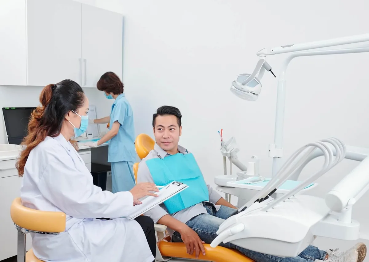 Dentist discussing with a patient how long after a tooth extraction they may need to wait before getting a dental implant.