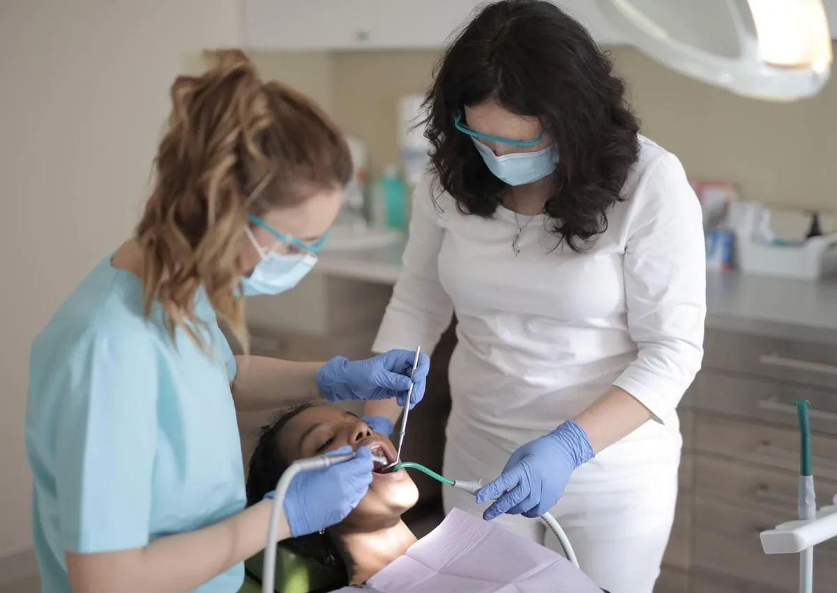 Dental team examining a patient to determine why a dental implant hurts when chewing.